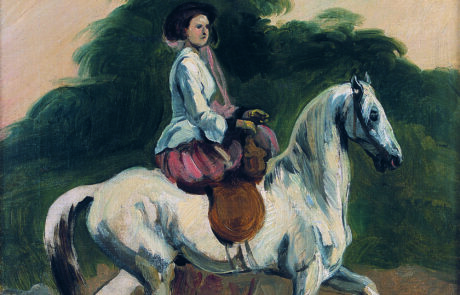 Na białym koniu w damskim siodle siedzi kobieta. W tle ciemnozielona roślinność i jasne niebo.