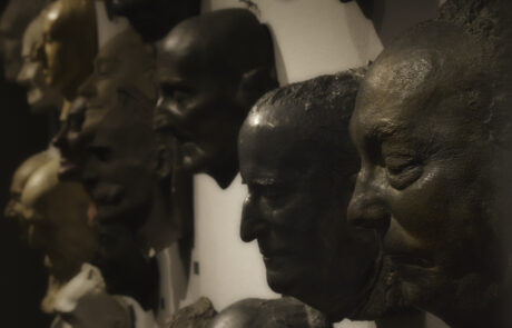 Fragment ściany z maskami pośmiertnymi znanych postaci życia publicznego autorstwa Alfonsa Karnego. Ujęcie z prawej strony.