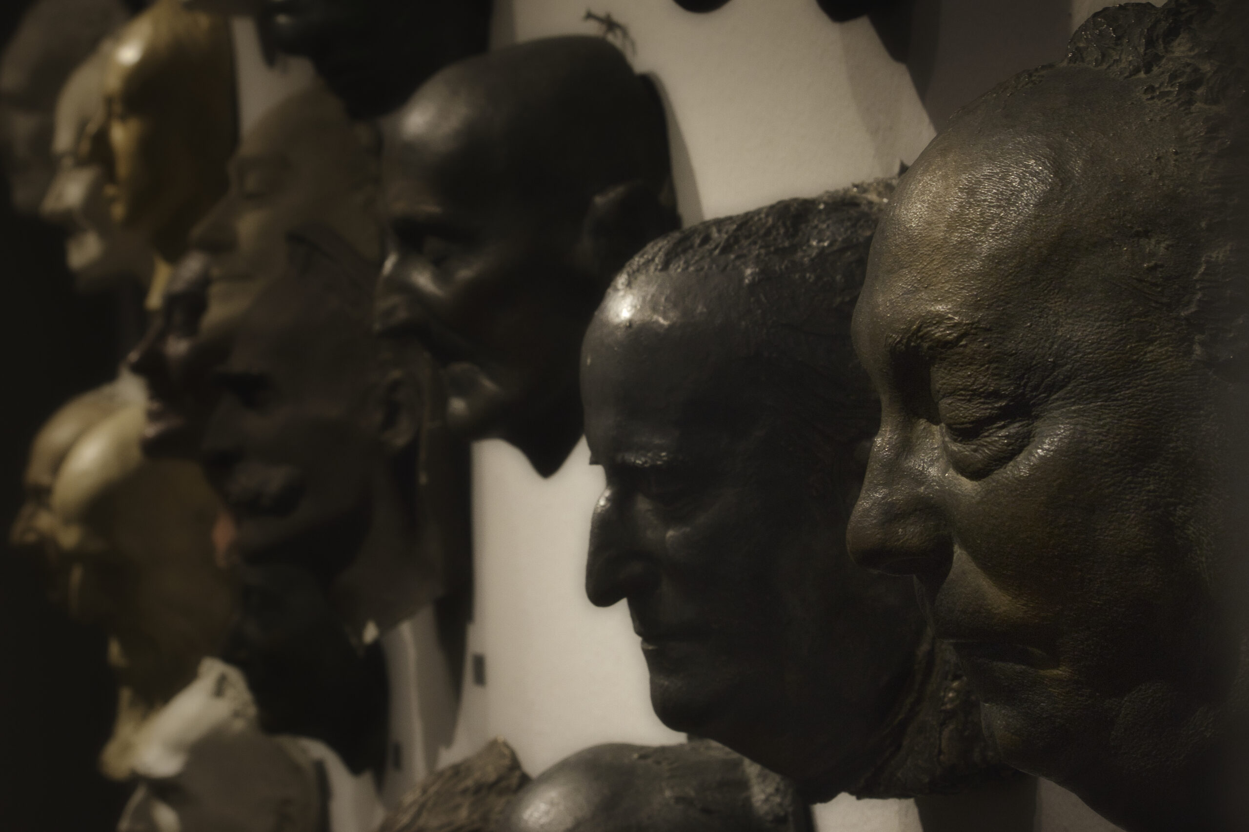 Fragment ściany z maskami pośmiertnymi znanych postaci życia publicznego autorstwa Alfonsa Karnego. Ujęcie z prawej strony.