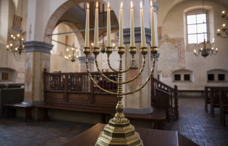 Siedmioramienny świecznik żydowski na tle wnętrza Wielkiej Synagogi.